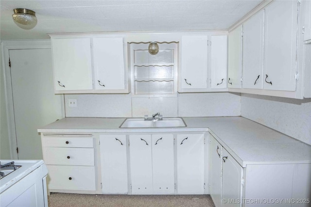 kitchen featuring white cabinetry, light countertops, and a sink