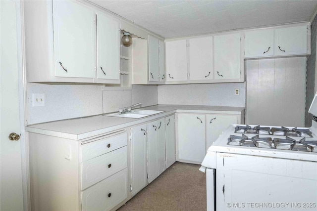kitchen with a sink, white range with gas cooktop, white cabinetry, and light countertops