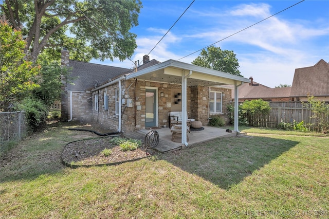 rear view of house featuring a yard, a fenced backyard, and a patio area