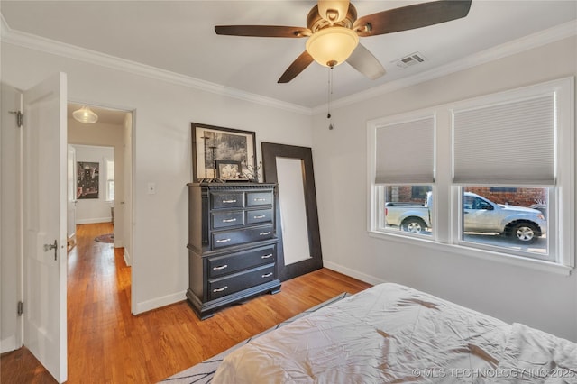 bedroom featuring baseboards, ornamental molding, and light wood finished floors