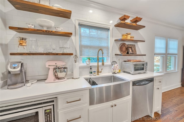 kitchen featuring ornamental molding, open shelves, a sink, stainless steel appliances, and decorative backsplash