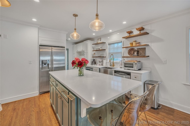 kitchen with light wood finished floors, open shelves, a sink, ornamental molding, and stainless steel appliances