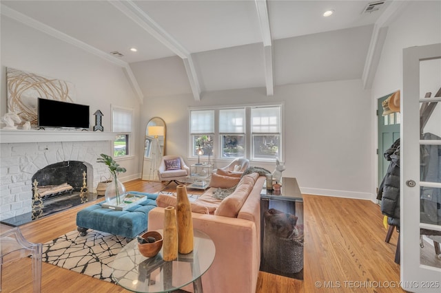 living room featuring baseboards, visible vents, vaulted ceiling with beams, a fireplace, and light wood-type flooring