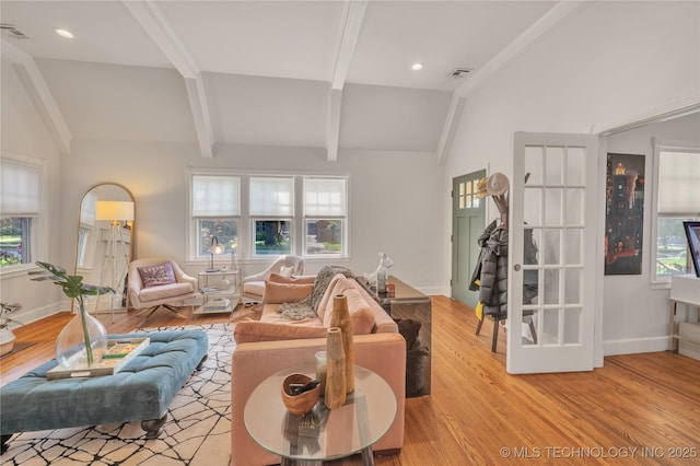 living room featuring light wood-type flooring, lofted ceiling with beams, and baseboards