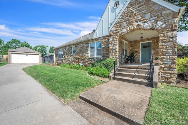 view of front facade featuring an outbuilding, a front yard, a porch, stone siding, and a detached garage