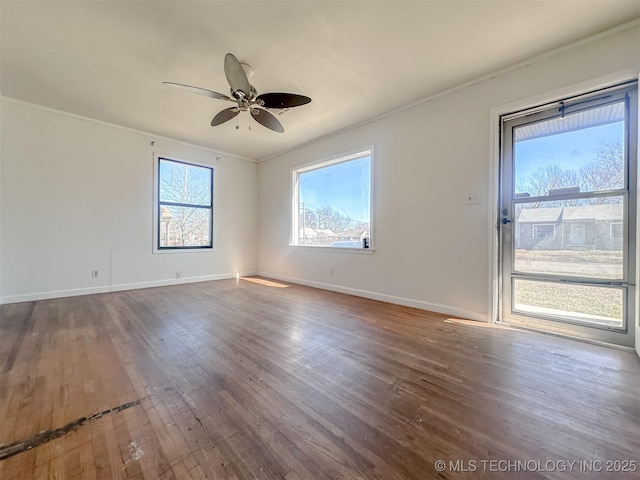 spare room with a ceiling fan, wood finished floors, and baseboards