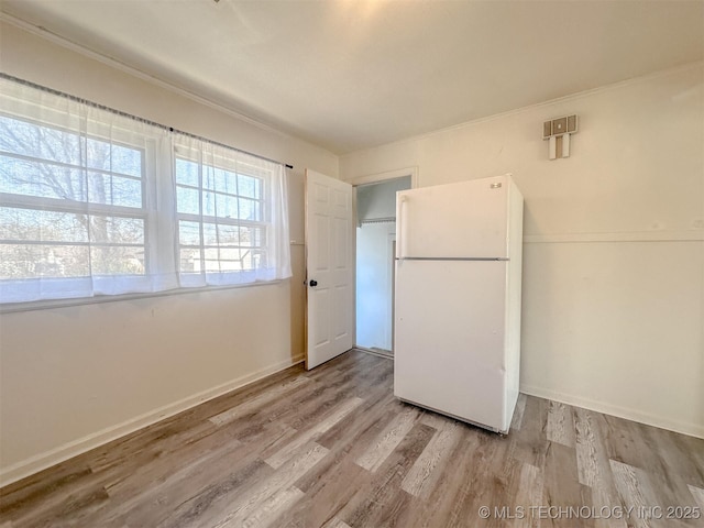 kitchen with freestanding refrigerator, baseboards, and wood finished floors