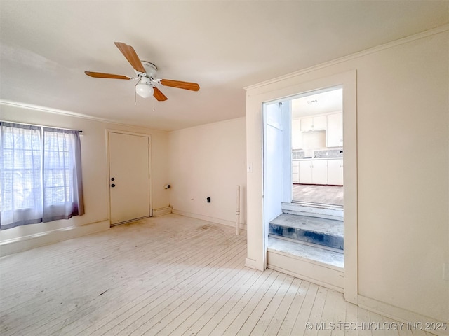 unfurnished room featuring a ceiling fan, light wood-style floors, and baseboards