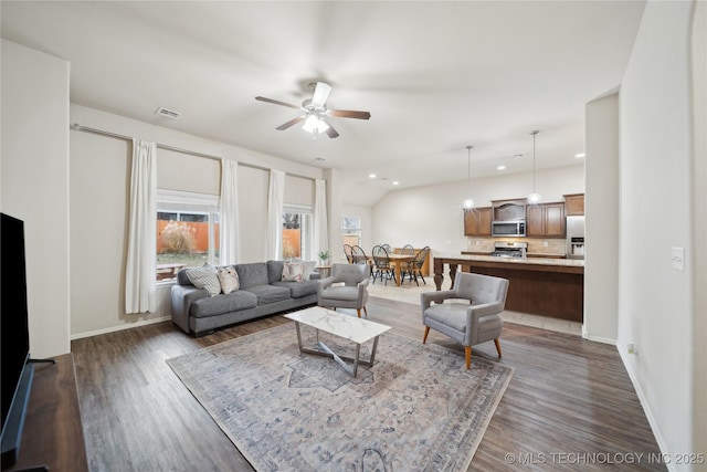 living room with dark wood-type flooring and a healthy amount of sunlight