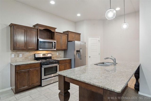 kitchen with backsplash, stainless steel appliances, a kitchen bar, and a sink