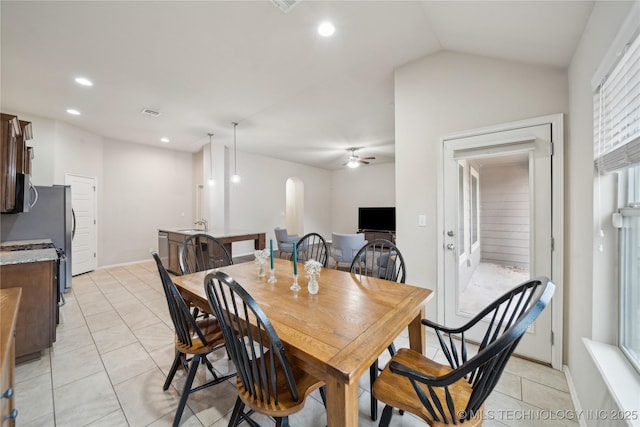 dining room with a ceiling fan, recessed lighting, arched walkways, light tile patterned floors, and vaulted ceiling