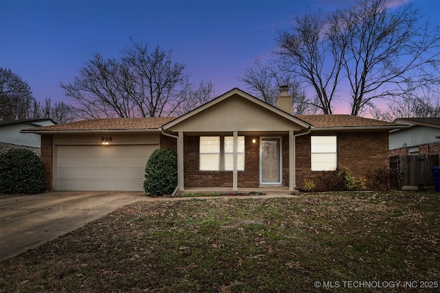 ranch-style home with roof with shingles, driveway, an attached garage, a chimney, and brick siding