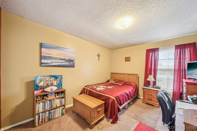 bedroom with a textured ceiling, baseboards, and carpet