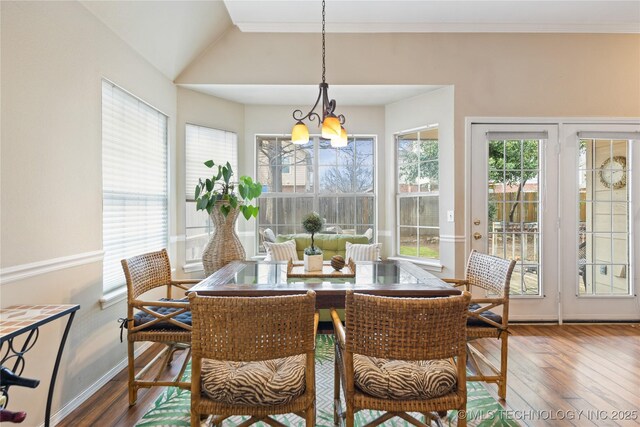 dining room featuring a chandelier, wood finished floors, crown molding, and vaulted ceiling