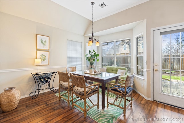 dining room featuring vaulted ceiling, dark wood-style floors, visible vents, and a healthy amount of sunlight