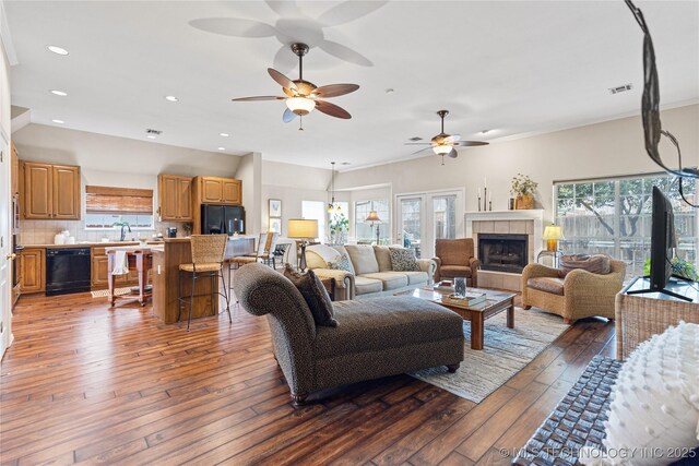 living area with a wealth of natural light, visible vents, and hardwood / wood-style flooring