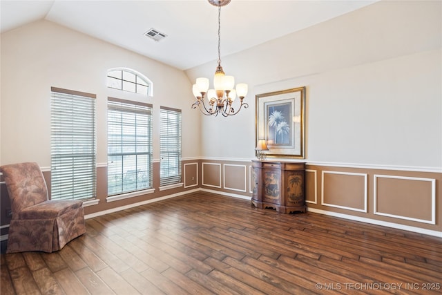 unfurnished dining area featuring visible vents, plenty of natural light, dark wood-type flooring, and vaulted ceiling