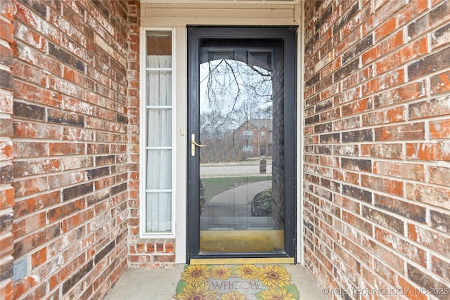 property entrance featuring brick siding