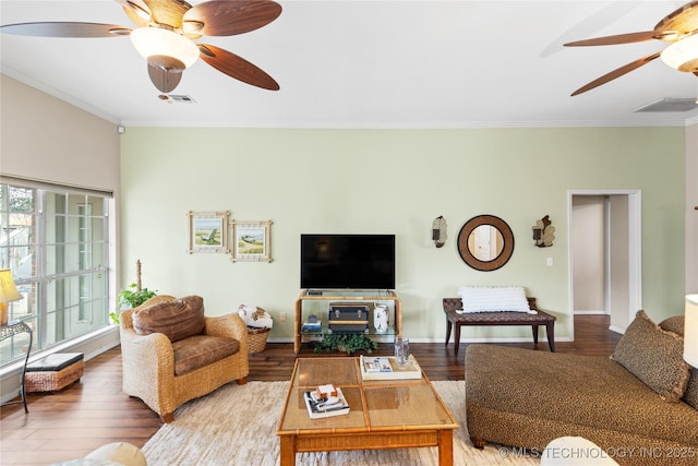 living area featuring visible vents, crown molding, a ceiling fan, and wood finished floors