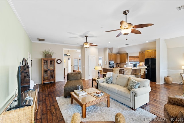 living area featuring visible vents, ornamental molding, baseboards, and hardwood / wood-style flooring