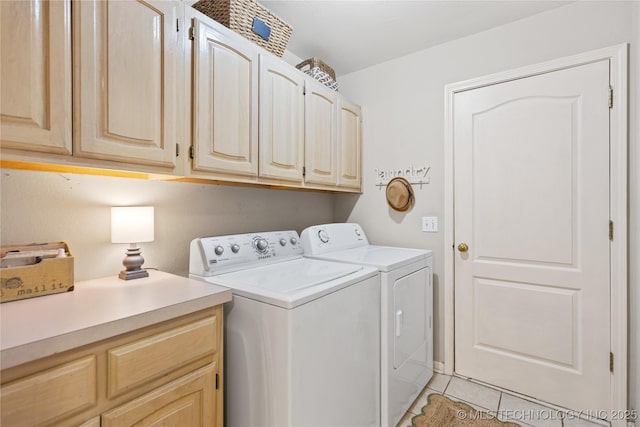 laundry room featuring washer and dryer, light tile patterned floors, and cabinet space