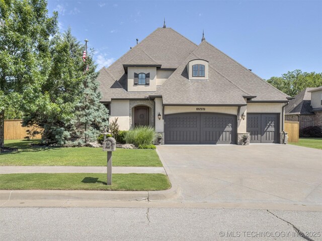 12491 S 105th Ave E, Bixby, OK 74008 - french country inspired facade featuring stucco siding, an attached garage, a shingled roof, and concrete driveway