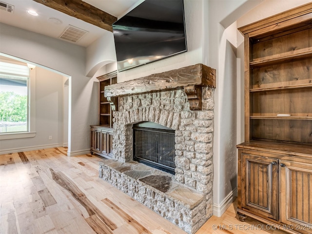 12491 S 105th Ave E, Bixby, OK 74008 - unfurnished living room with a stone fireplace, light wood-type flooring, baseboards, and beamed ceiling