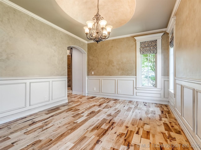 12491 S 105th Ave E, Bixby, OK 74008 - unfurnished dining area with arched walkways, light wood-style floors, a chandelier, a wainscoted wall, and crown molding