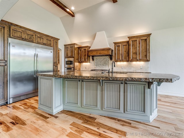 12491 S 105th Ave E, Bixby, OK 74008 - kitchen featuring built in appliances, premium range hood, beam ceiling, tasteful backsplash, and a sink