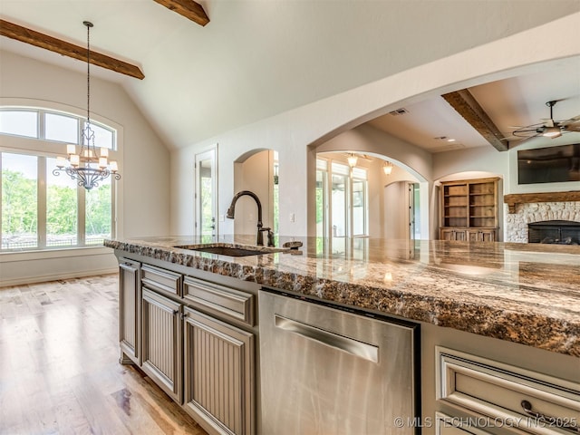 12491 S 105th Ave E, Bixby, OK 74008 - kitchen with stainless steel dishwasher, a sink, ceiling fan, open floor plan, and arched walkways