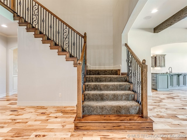 12491 S 105th Ave E, Bixby, OK 74008 - stairway with arched walkways, wood finished floors, recessed lighting, baseboards, and beam ceiling