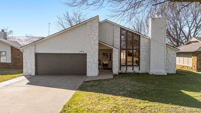 mid-century inspired home featuring a garage, a front yard, a chimney, and driveway