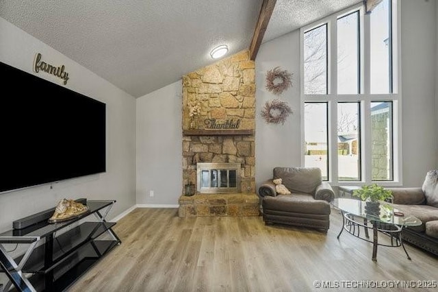 living area with high vaulted ceiling, a textured ceiling, wood finished floors, a fireplace, and baseboards