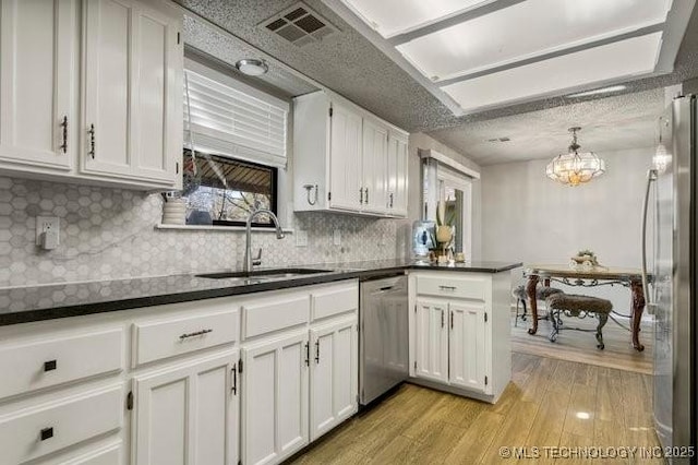 kitchen with visible vents, light wood-type flooring, white cabinets, stainless steel appliances, and a sink