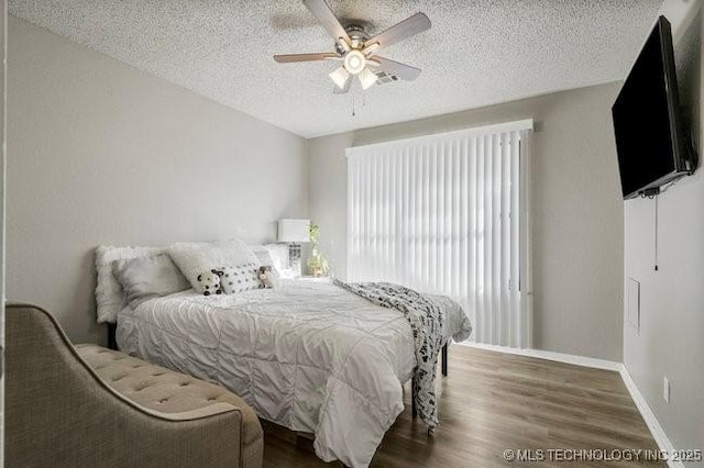 bedroom featuring a textured ceiling, a ceiling fan, baseboards, and wood finished floors