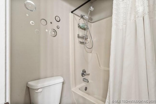 bathroom featuring shower / tub combo and toilet