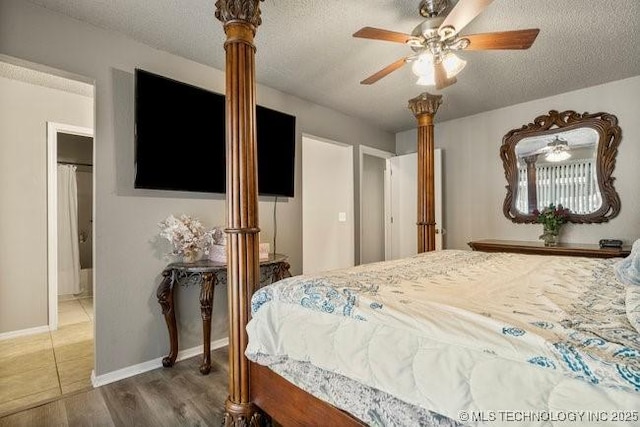 bedroom with ceiling fan, a textured ceiling, baseboards, and wood finished floors