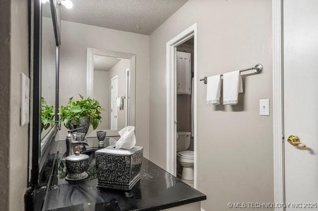 interior space featuring toilet and a textured ceiling