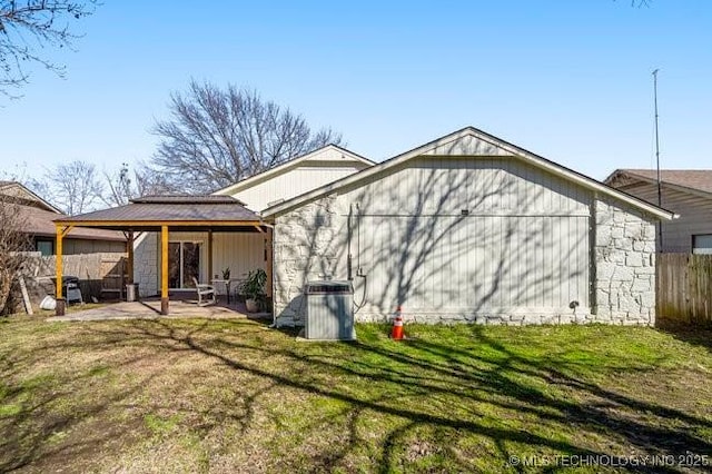 rear view of house with a patio, a yard, and fence