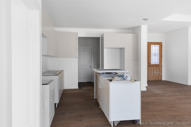 kitchen featuring visible vents, dark wood-type flooring, light countertops, white cabinets, and modern cabinets