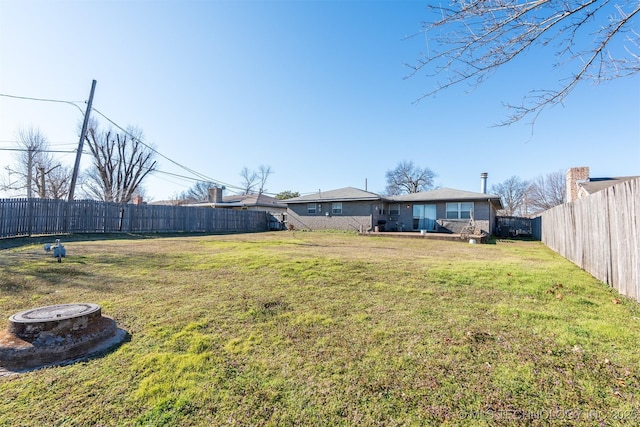 view of yard with a fire pit and a fenced backyard