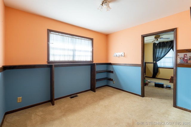 carpeted spare room featuring baseboards and visible vents