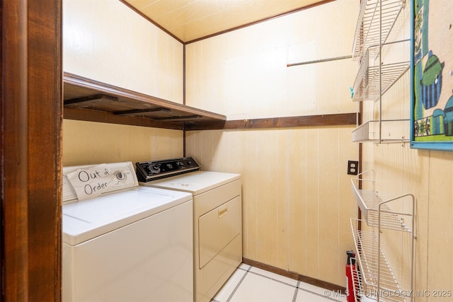 washroom featuring laundry area, washer and dryer, and wooden walls