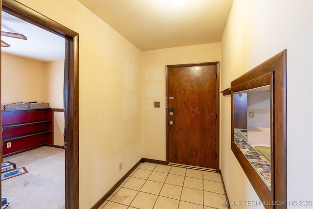 doorway featuring light tile patterned flooring and baseboards