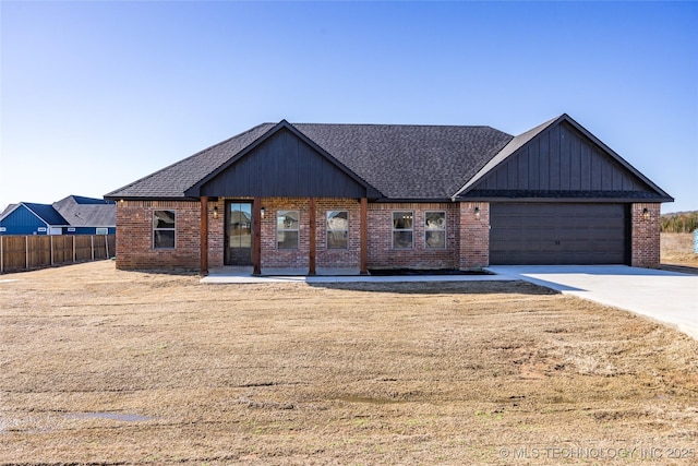 view of front of property featuring brick siding, a shingled roof, and fence