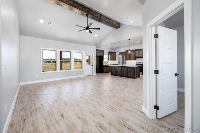 unfurnished living room featuring visible vents, beam ceiling, light wood finished floors, baseboards, and ceiling fan