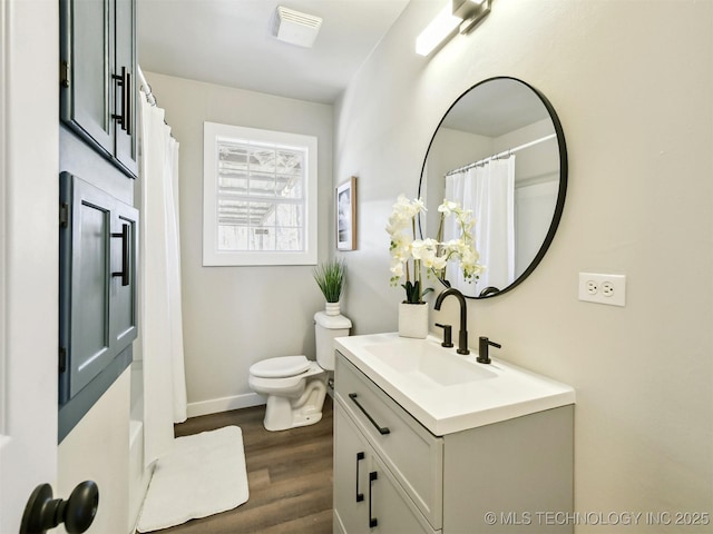 full bathroom with baseboards, toilet, wood finished floors, and vanity