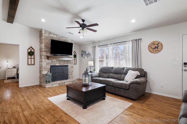 living room featuring lofted ceiling with beams, visible vents, and light wood-style floors