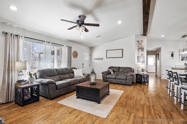 living area featuring a ceiling fan, visible vents, vaulted ceiling with beams, recessed lighting, and light wood-type flooring