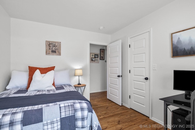 bedroom featuring baseboards and wood finished floors